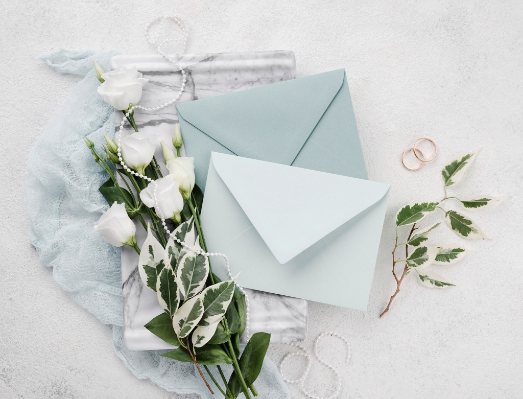 Hochzeitskarten mit blauen Briefumschlägen und weißen Rosen