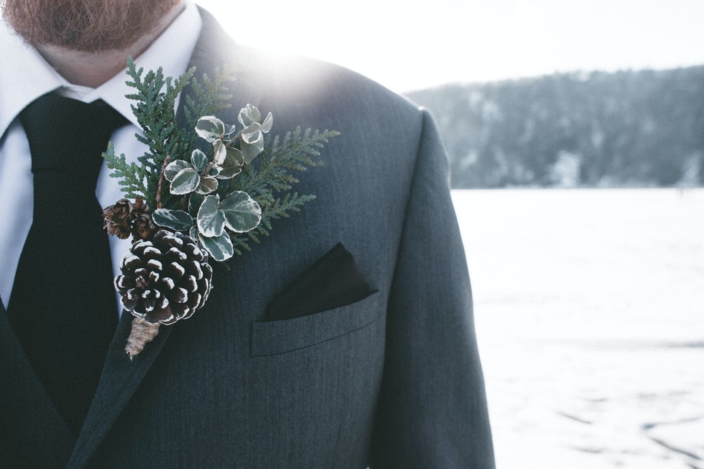 Bei einer Winterhochzeit kann der Anzug des Bräutigams mit Tannenzapfen und Zweigen verschönert werden.