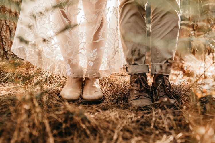 Die Füße von einem Hochzeitspaar mit gebrauchten flachen Schuhe